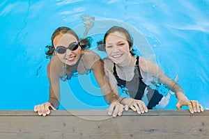 Two young teenage girls having fun in the swimming pool