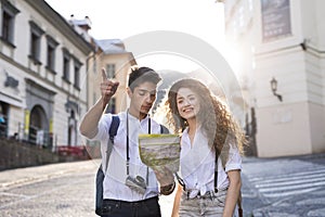Two young tourists with map and camera in the old town.