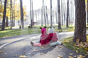 two young twin sisters sitting on ground