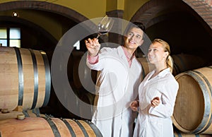 Two young wine house workers checking quality of product