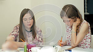 Two young woman artist painting at home studio creative tools