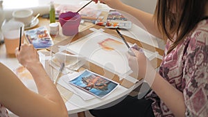 Two Young woman artist painting at home studio creative tools