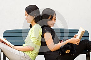 Two young woman enjoy reading