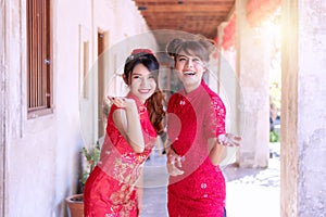 Two young woman friend wear cheongsam red dress holding hands looking at the soap bubble feeling fun.