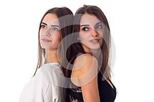 Two young woman standing back to back