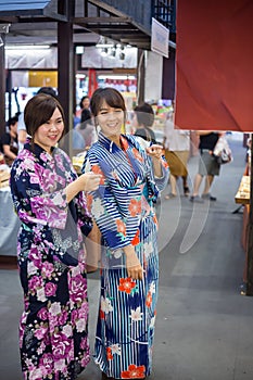 Two young woman wearing japanese traditional kimono enjoy the stroll