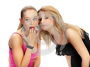 Two young woman wispering secrets photo