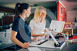 Two young woman working in printing factory