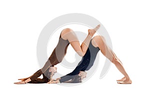 Two young women doing yoga asana Downward Facing Dog