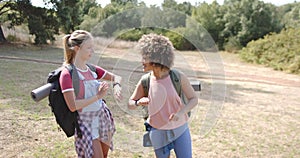 Two young women are engaged in a lively conversation outdoors
