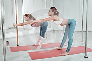 Two young women exercising in a training hall.