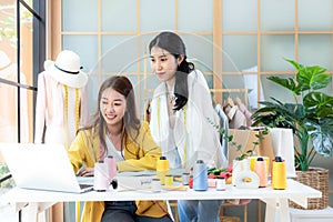 Two young women fashion designer working on her designer in the showroom.