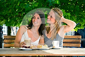 Two young women friends in street cafe