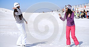Two young women having a snow fight