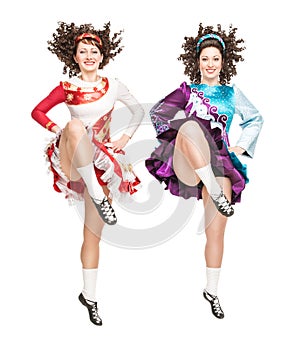 Two young women in irish dance dress dancing isolated