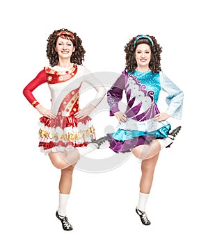 Two young women in irish dance dress dancing isolated