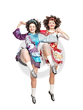 Two young women in irish dance dress dancing isolated