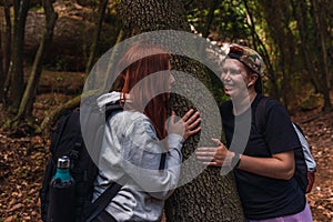 two young women looking at each other romantically in the shade of a tree. young people on vacation.