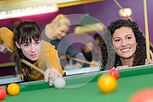 two young women playing pool