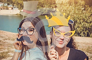 Two young women posing using photo booth props