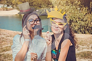 Two young women posing using photo booth props