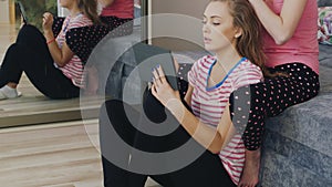 Two young women relaxing at home, enjoying the tablet, braid hair. Pajama party girlfriends