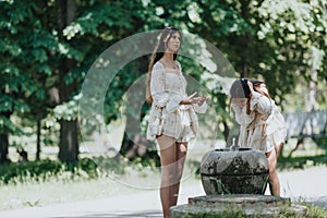 Two young women in summer dresses enjoying a sunny day at the park