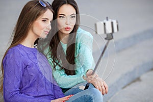 Two young women taking pictures with your smartphone.