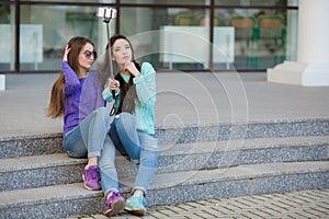 Two young women taking pictures with your smartphone.