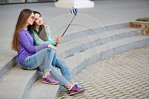 Two young women taking pictures with your smartphone.