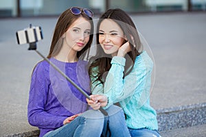 Two young women taking pictures with your smartphone.