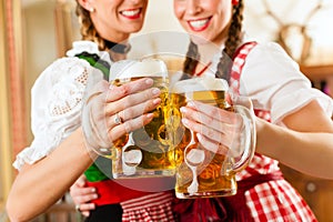 Two young women in traditional Bavarian Tracht in restaurant or pub