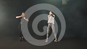 Two young women training their styles of dancing