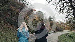 Two Young Women Walking In Autumn Park Fall Day. Friendship Concept