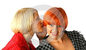 Two young women whispering and surprised