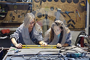 two young women working in a mechanic shop