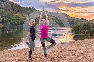 Two young women working out on a sandy beach