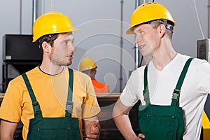 Two young workers in production area