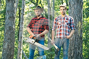 Two ypung Lumberjack man holds axe. Brutal lumberjack concept.