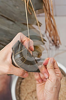 Tying freshly made Asian dumplings