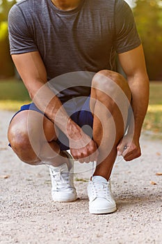 Tying lace shoelace shoes runner young man ready preparing start portrait format running sports
