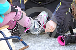 Tying laces of ice hockey skates skating rink