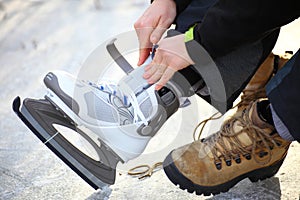 Tying laces of ice hockey skates skating rink