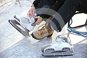 Tying laces of ice hockey skates skating rink