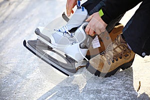 Tying laces of ice hockey skates skating rink