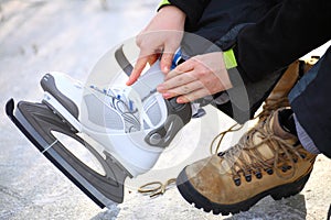 Tying laces of ice hockey skates skating rink