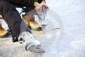 Tying laces of ice hockey skates skating rink