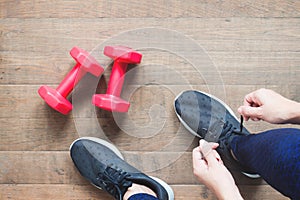 Tying sport shoes, Asian woman getting ready for weight training. Exercise, Fitness training. Healthy lifestyle