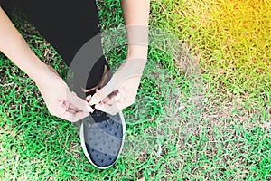 Tying sport shoes on yard, Asian woman getting ready for running, Outdoor sport, Exercise, Fitness training. Healthy lifestyle