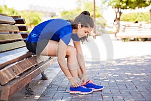 Tying tennis shoes in a park